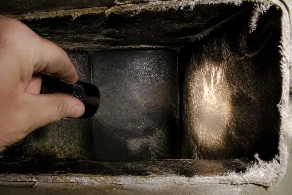 The coated inner surface faces the airstream; damage or wetting is what raises air quality concerns.