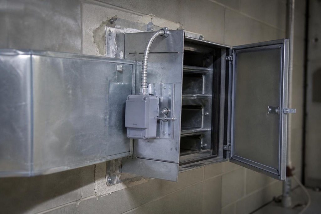 A combination fire and smoke damper: the actuator closes it on a smoke signal, the heat link on fire.