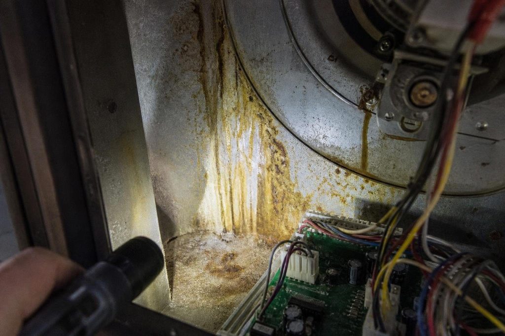 Rust and mineral tracks show where water has run toward the electronics.