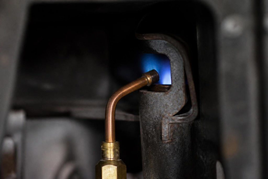 A healthy pilot flame should wrap the thermocouple tip; a weak or yellow flame is a common reason the pilot drops out.