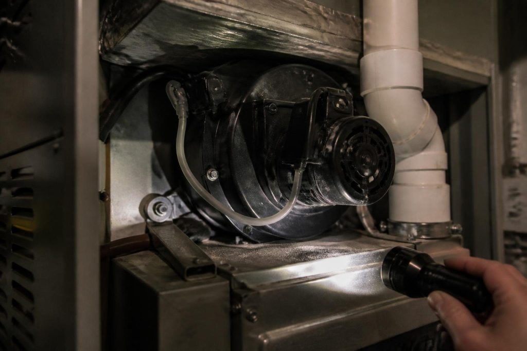 The draft inducer sits on the collector box and pulls flue gases into the vent.